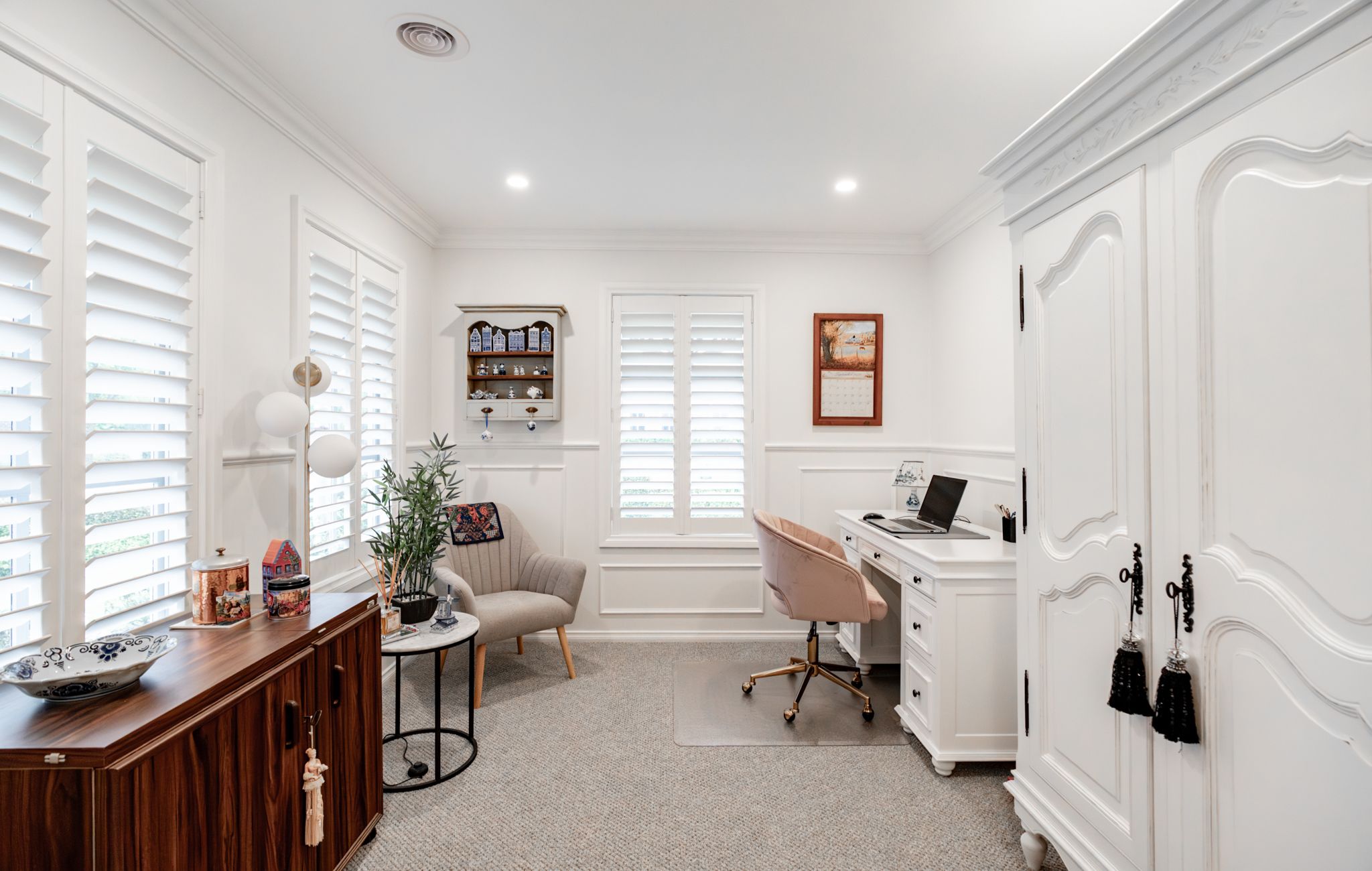Study with plantation shutters, wall panelling and a white desk