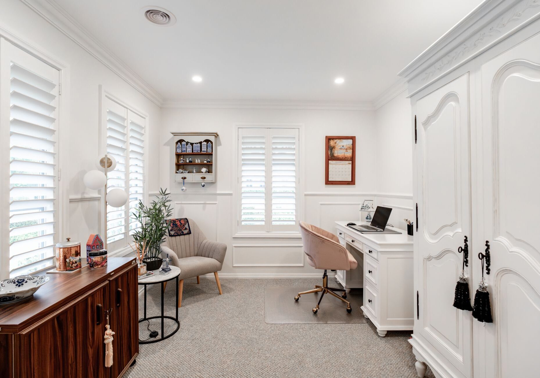 Study with plantation shutters, wall panelling and a white desk